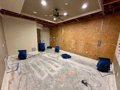 Air movers drying a stripped room after water damage in Fullerton