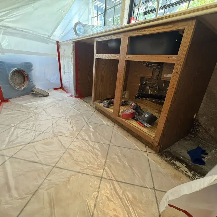 Cabinet base opened under containment for drying in Fullerton
