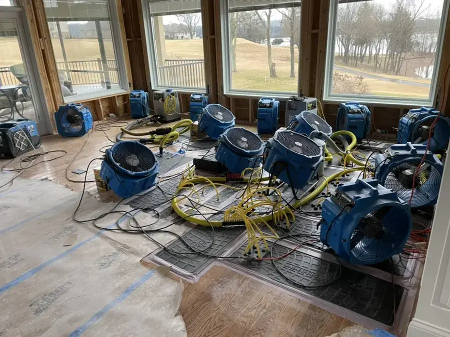 Air movers and drying hoses running in a water-damaged Fullerton home