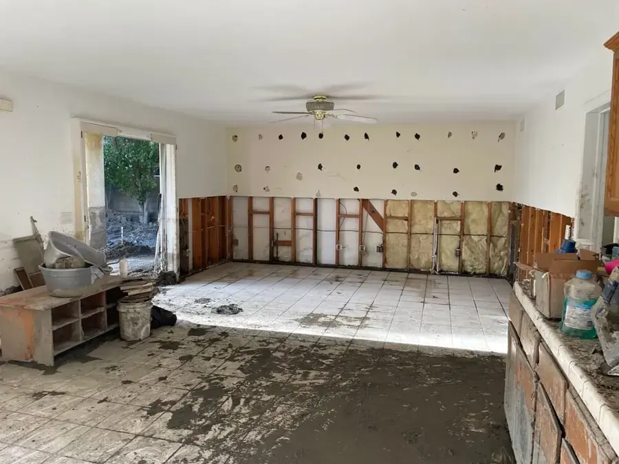 Flood-cut walls and wet floor after water damage in a Fullerton home