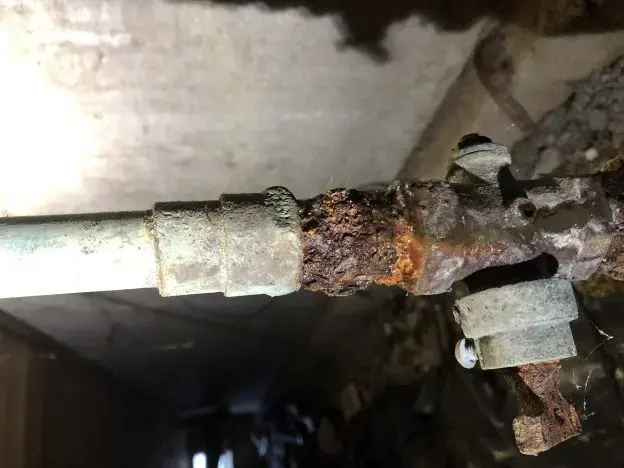 Rusted galvanized supply pipe leaking in an older Fullerton house
